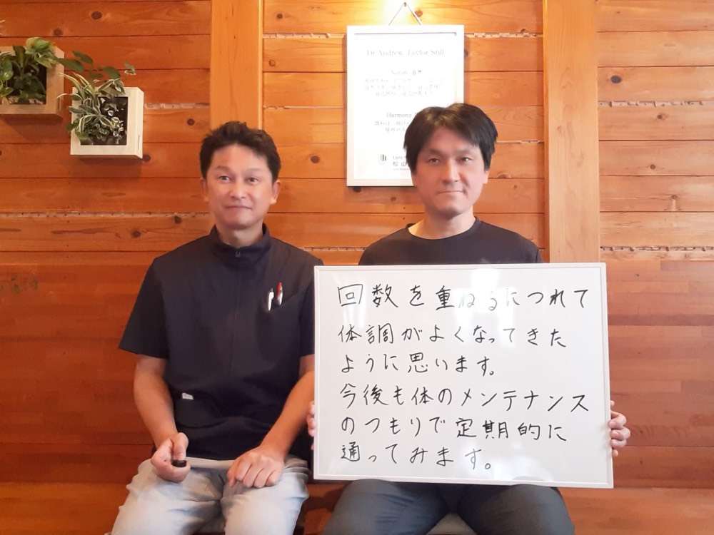 ホワイトボードを持つお客様と院長のツーショット